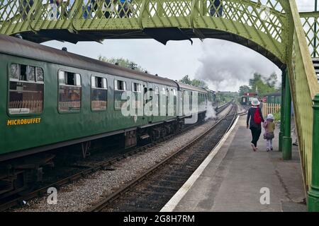 Train à vapeur sur la plate-forme de la gare du château de Corfe avec les voyageurs marchant le long de la plate-forme. Château de Corfe, Dorset - Angleterre. Banque D'Images