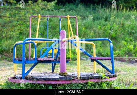 Aire de jeux abandonnée. Carrousel rouillé non fonctionnel. Jeux pour enfants. Banque D'Images