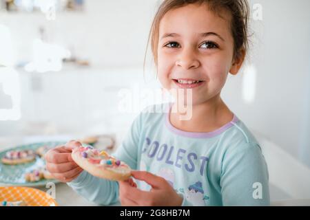 Jeune fille souriant avec un cookie de pâques décoré Banque D'Images