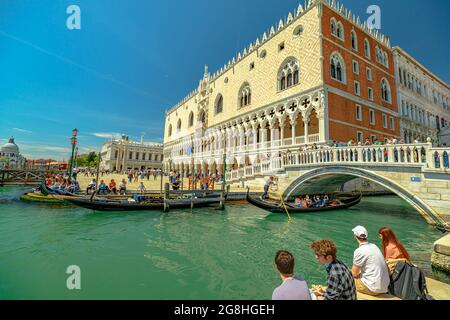 Venise, Italie - 9 mai 2021 : gondoles traditionnelles pour une croisière touristique sur le canal de Giudecca par la place Saint-Marc avec le palais de Doge. Le principal et le plus grand Banque D'Images
