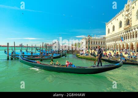 Venise, Italie - 9 mai 2021 : service de télécabines traditionnelles avec des touristes en tournée sur le Canal Grande par la place Saint-Marc. Le plus grand canal de Venise Banque D'Images