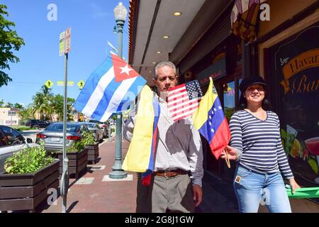 Miami, Floride, États-Unis. 18 juillet 2021. Un couple marchant avec les drapeaux de Cuba, du Venezuela et des États-Unis, lors d'une manifestation en faveur de la liberté cubaine à la Peque'a Habana. (Credit image: © Fernando Oduber/SOPA Images via ZUMA Press Wire) Banque D'Images