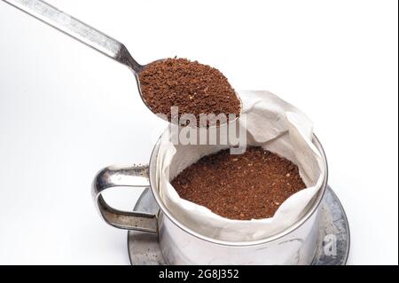 verser la poudre de café moulu dans le papier filtre pour la poivrer afin de l'égoutter Banque D'Images