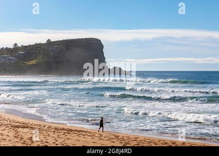 L'homme australien s'exerce seul en faisant du jogging le long d'Avalon Beach lors d'une journée d'hiver dans le ciel bleu, Sydney, Australie Banque D'Images