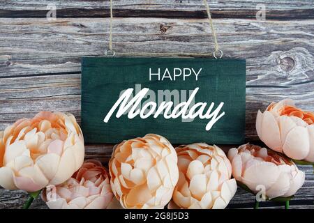 Texte typographique de Happy Monday avec bouquet de fleurs oranges sur fond en bois Banque D'Images