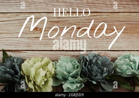Bonjour lundi texte typographique avec bouquet de fleurs bleues sur fond en bois Banque D'Images