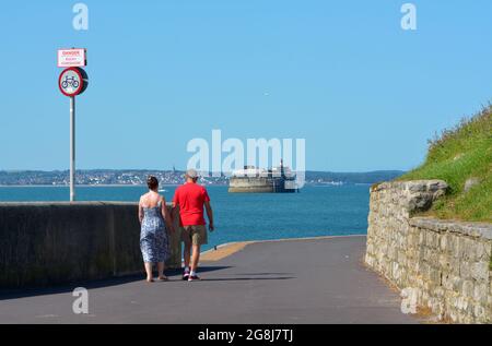 Quelques personnes marchent sur la promenade le long du bord de mer de Southsea, cette partie est courbe autour de vous permettant une vue sur le fort de Spitbank et l'île de White. Banque D'Images