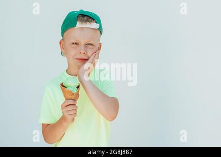 Portrait d'un garçon qui mange de la crème glacée et du feutre mal de dents. Soins dentaires, concept de soins de santé Banque D'Images