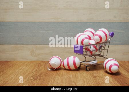 Mini chariot avec oeufs de Pâques avec copie de l'espace sur fond en bois Banque D'Images