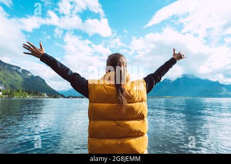Jeune femme insouciante voyageur à bras ouverts jouissant d'une vue magnifique sur le lac de Genève en Suisse. Banque D'Images