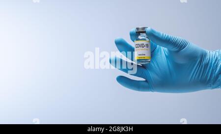 Médecin mains dans des gants en latex bleu tenant un flacon en verre avec un médicament. Vaccination et concept médical. Banque D'Images