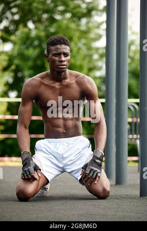 Athlète se reposant entre des exercices en plein air, des exercices en plein air, des exercices afro-américains sur le terrain de sport Banque D'Images