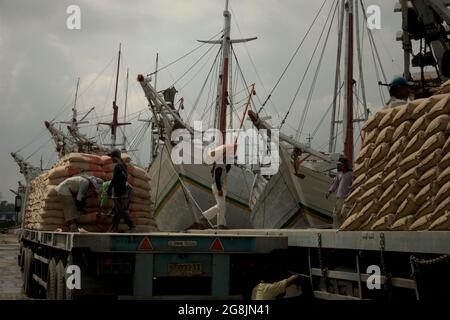 Les travailleurs transportent des sacs de ciment d'un camion sur un navire phinisi au port traditionnel de Sunda Kelapa à Penjaringan, dans le nord de Jakarta, à Jakarta, en Indonésie. Banque D'Images