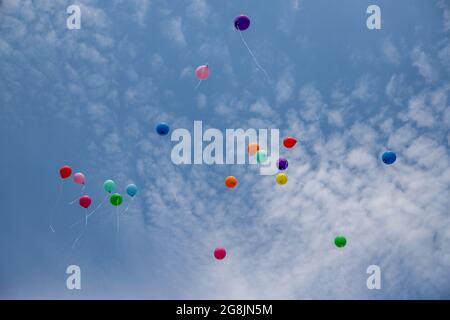 Nombreuses couleurs ballons volent dans le ciel bleu avec de nombreux nuages blancs en été, pendant la partie Banque D'Images