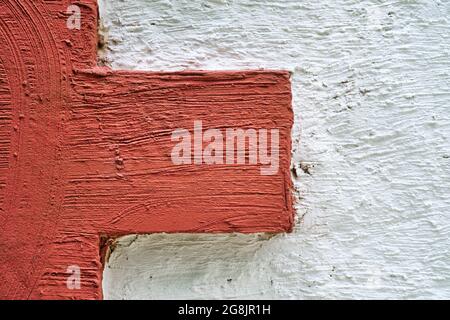 Mur en pierre blanc avec stuc rouge quoin. Arrière-plan de la conception du mur extérieur. Banque D'Images