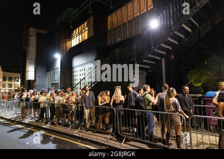 Les clubbers se dirigent vers la discothèque Oval Space en début de journée, où les salles de concert ont été autorisées à rouvrir à 00.01 h le 19 juillet. Banque D'Images