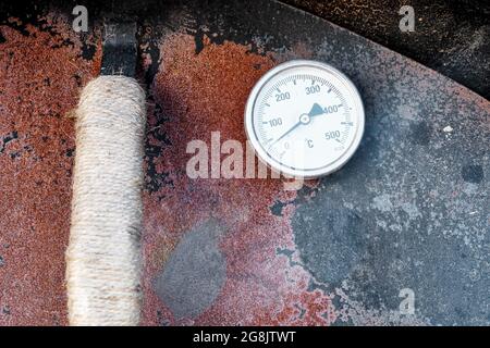 Porte en métal rouillé d'un four en pierre avec thermomètre thermique. Vue de détail rapprochée. Banque D'Images