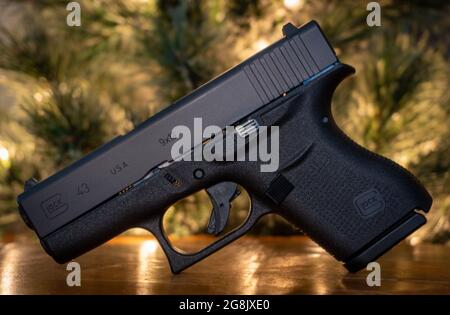 JONESBORO AR, ÉTATS-UNIS - 19 juillet 2021 : pistolet Glock 43 avec fond d'arbre sur une surface en bois Banque D'Images