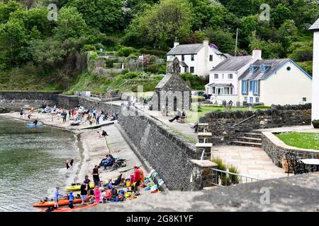 Les gens apprécient leur temps sur la plage dans la pittoresque MCG-yr-Eglwys, Pembrokeshire, au sud du pays de Galles. Il a été rapporté que le petit village de bord de mer a plus de maisons de vacances que les résidents permanents, avec les locaux étant hors prix du marché de l'immobilier. Seulement deux des cinquante propriétés du village abritent maintenant des locaux. Banque D'Images