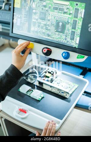 Woman examine les microcircuits sur un appareil spécial pour la lecture des malvoyants. Banque D'Images