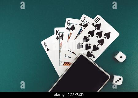 jeux de cartes poker dés et téléphone sur tissu bleu vert Banque D'Images