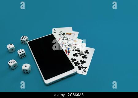 jeux de cartes poker dés et téléphone sur tissu bleu vert Banque D'Images