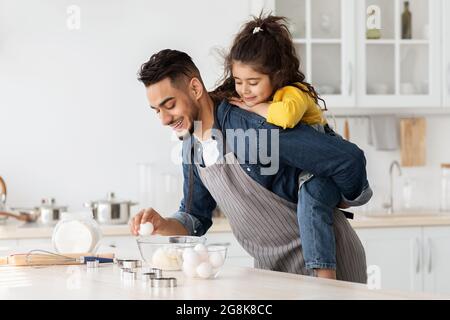 Portrait du jeune Père arabe qui cuit en cuisine avec sa petite fille Banque D'Images