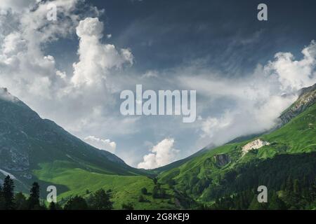 Rochers et un col avec un ciel bleu avec des rayons de soleil qui se brisent à travers les nuages. Fisht Oshten est un sommet de montagne dans la partie ouest du Caucase principal Banque D'Images