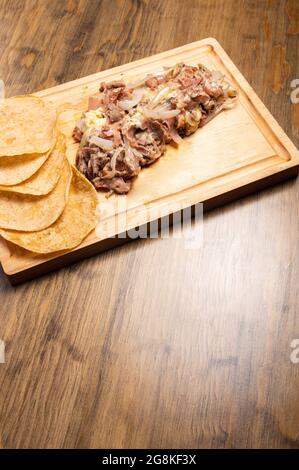 Dose verticale de viande hachée cuite avec des oignons sur une planche de bois Banque D'Images