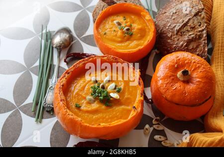 Soupe crémeuse et nourrissante de courge musquée avec une tranche de pain croustillant. Nourriture de confort d'automne. Concept de saine alimentation. Banque D'Images