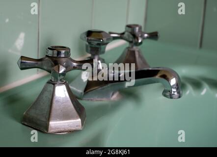 Gros plan sur le lavabo original vert vintage rétro des années 1930 deco et les robinets en acier inoxydable. Banque D'Images