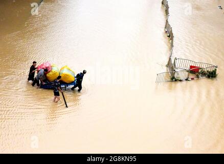 Zhengzhou, province chinoise du Henan. 21 juillet 2021. Les citoyens transportent leur propriété dans une rue inondée de Zhengzhou, dans la province du Henan, au centre de la Chine, le 21 juillet 2021. Les pluies ont submergé la province de Henan dans le centre de la Chine depuis le week-end. Credit: Zhu Xiang/Xinhua/Alamy Live News Banque D'Images