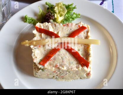 Légumes en dés, œufs durs et salade de thon garnie de mayonnaise. Avec quelques bandes de poivron rouge, une asperge et une petite laitue. Banque D'Images