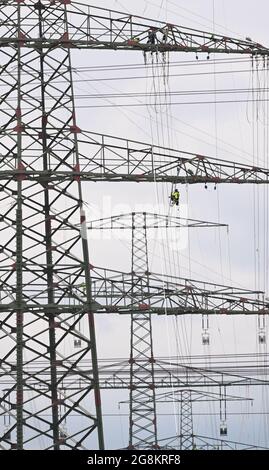 21 juillet 2021, Brandebourg, Ahrensfelde/OT Lindenberg: Un ouvrier pend du boom d'un pylône haute tension par son fusible. Des lignes aériennes à très haute tension sont actuellement mises en place sur une route de 380 kilovolts à l'extérieur de la périphérie nord de Berlin. Photo: Soeren Stache/dpa-Zentralbild/ZB Banque D'Images