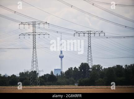 21 juillet 2021, Brandebourg, Ahrensfelde/OT Lindenberg : des pylônes haute tension se tiennent au bord d'un cornfield sur fond de tour de télévision de Berlin. Des lignes aériennes à très haute tension sont actuellement mises en place sur une route de 380 kilovolts à l'extérieur de la périphérie nord de Berlin. Photo: Soeren Stache/dpa-Zentralbild/ZB Banque D'Images