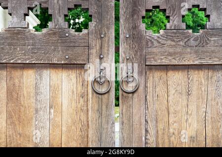 Ancienne grille en bois avec poignées rondes forgées. Banque D'Images