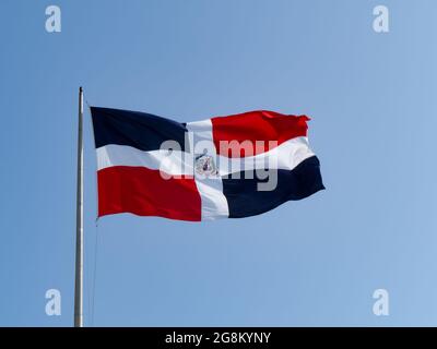 Les drapeaux dominicains agitant avec le ciel bleu en arrière-plan Banque D'Images