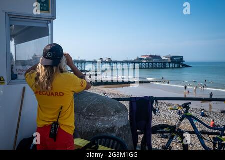 Angleterre, Norfolk, Cromer. 18 juillet 2021. Un sauveteur RNLI observe la plage près de Cromer Pier pendant la vague de chaleur estivale. Banque D'Images