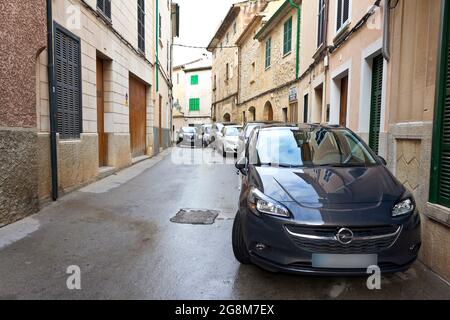 Pollenca, Majorque ou Majorque, Espagne - 6 février 2015 : ancienne route étroite sans trottoir ou trottoir, voitures garées directement devant les portes. Banque D'Images