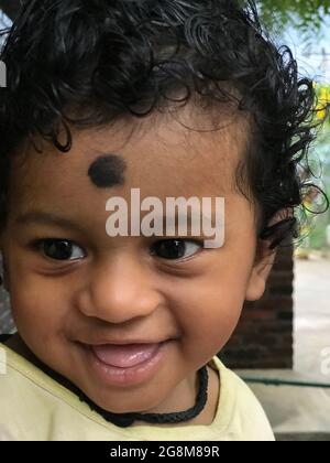 Bébé indien avec des cheveux de curling noirs ou bébé souriant avec rire Banque D'Images