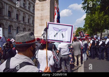 Londres, Royaume-Uni. 21 juillet 2021. Un démonstrateur tient un écriteau portant le logo de la Brigade de Gurkhas à côté du mémorial de guerre de Cenotaph pendant la manifestation. Les manifestants se sont rassemblés à Westminster pour réclamer que le gouvernement britannique réagisse à leurs griefs, notamment les pensions inégales qui, selon les manifestants, sont accordées aux anciens combattants de l'armée Gurkha par rapport à leurs homologues britanniques. Crédit : SOPA Images Limited/Alamy Live News Banque D'Images