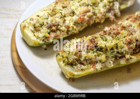 Courgettes ou courgettes farcies au bœuf haché, au bacon, aux oignons et à la crème, cuites au four, gros plan, mise au point sélectionnée, faible profondeur de champ Banque D'Images