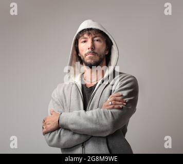 Portrait d'un homme italien confiant portant une veste à capuche et debout avec des bras croisés Banque D'Images