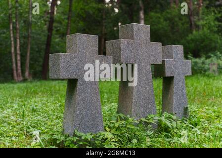 Trois croix de pierre dans un cimetière dans la forêt. Banque D'Images