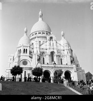 Années 1950, image historique de la Basilique du Sacré coeur de Paris, plus communément connue sous le nom de Sacré-coeur, une église catholique romaine construite au sommet de la colline de Montmartre, Paris, France. Ce monument emblématique a été consacré en 1919 et est le deuxième bâtiment religieux le plus visité de Paris. Banque D'Images