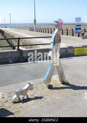 Une sculpture en métal d'un homme et d'un chien de match célèbre l'artiste LS Lowry à l'endroit où il a peint dans le village côtier de Lancashire, à Knott End Banque D'Images