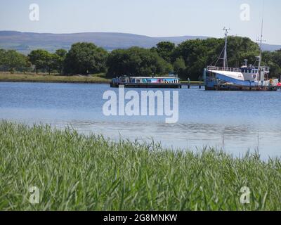 Vue sur le bassin de Glasson pendant une journée d'été avec des bateaux colorés amarrés à des jetées et les collines qui s'élève au loin. Banque D'Images