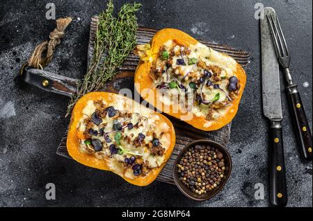 Citrouille farcie de viande de bœuf hachée, de légumes et d'herbes fond noir. Vue de dessus Banque D'Images