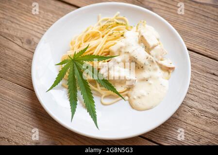 Cannabis nourriture nature herbe concept, Spaghetti carbonara sur l'assiette avec feuille de cannabis - plante de feuilles de marijuana Banque D'Images