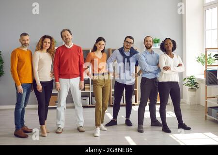 Des jeunes adultes multiraciaux et variés se tenant ensemble dans un bureau lumineux Banque D'Images